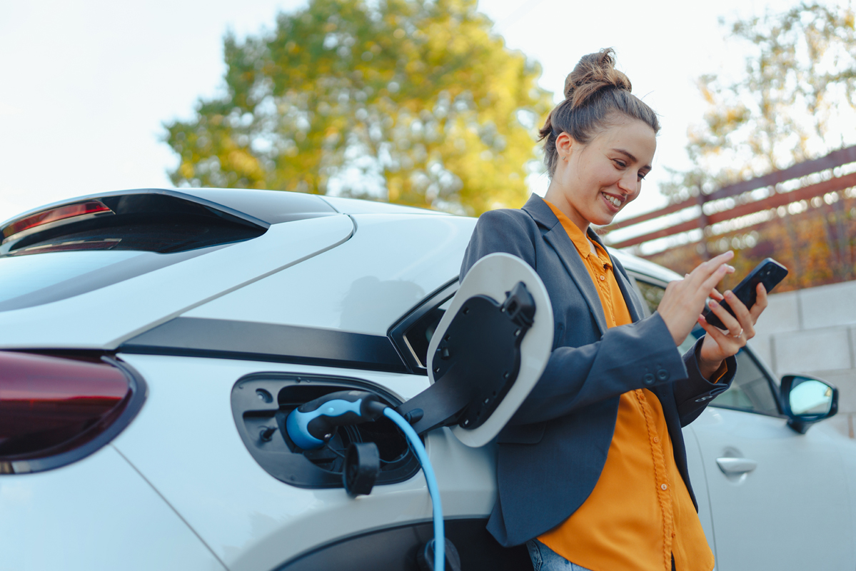 Frau ladet Elektro Auto